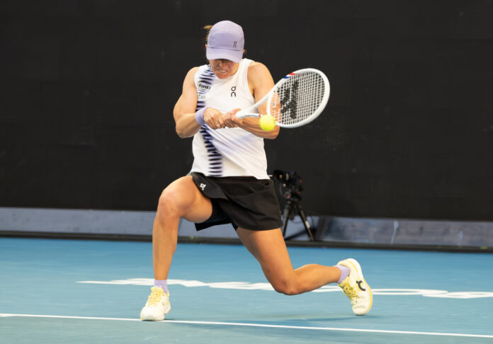 Iga Swiatek hits a return at the Australian Open