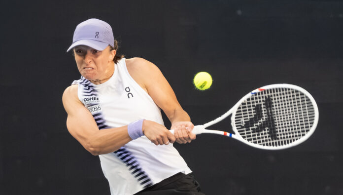 Iga Świątek hits a two-handed backhand at the 2026 Australian Open.