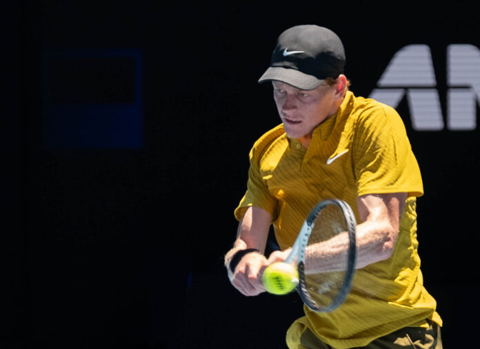 Jannik Sinner of Italy hits a return at the Australian Open 2026