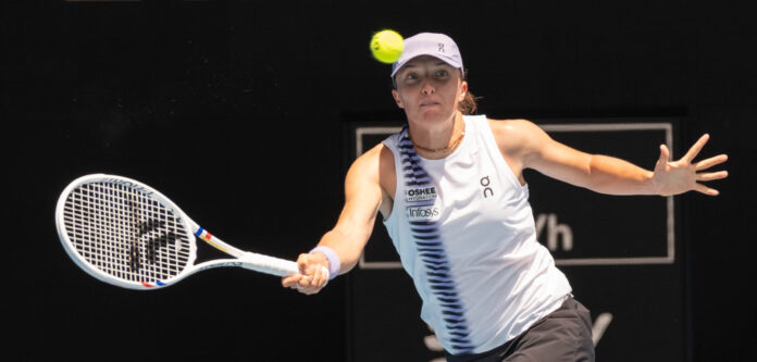 Iga Swiatek hits a return at the Australian Open 2026