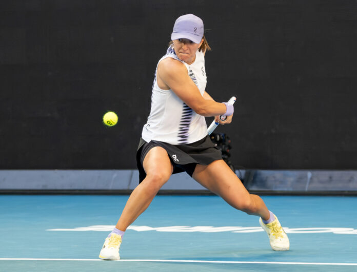 Iga Swiatek looks to hit a return at the Australian Open 2026