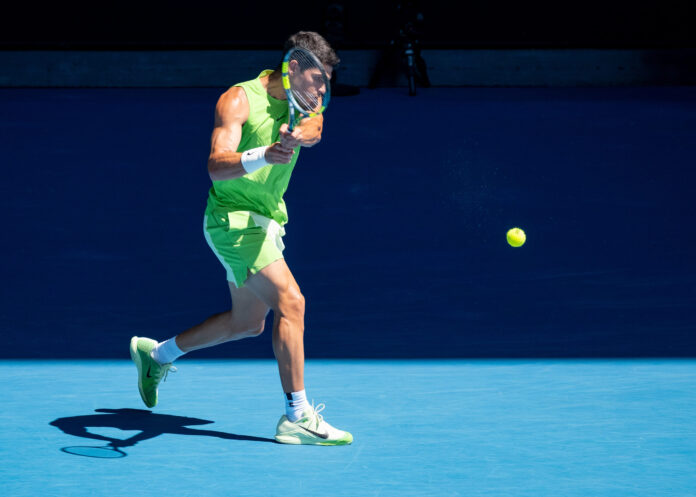 Carlos Alcaraz hits a return on his way to winning the Australian Open 2026 and before the wrist issues