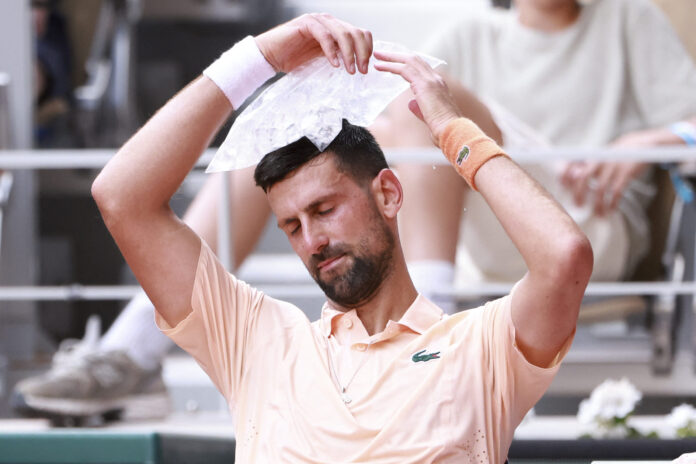 Novak Djokovic of Serbia fights the heat with a icebag