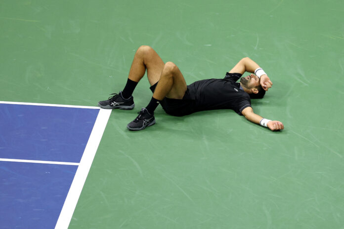 Novak Djokovic of Serbia falls against Mariano Navone of Argentina