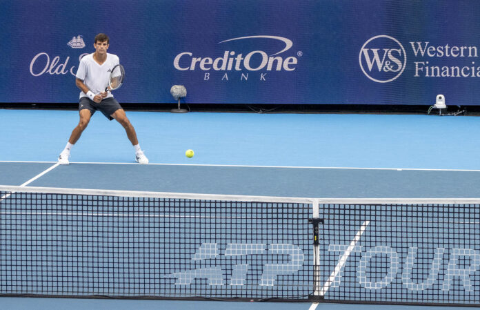A tennis ball bouncing on a blue hard court as a player at the far baseline waits to return serve at the Cincinnati Open